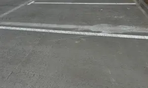 Nowe miejsca parkingowe z białymi liniami wyznaczającymi. Różne rodzaje betonu tworzą trwałą nawierzchnię.