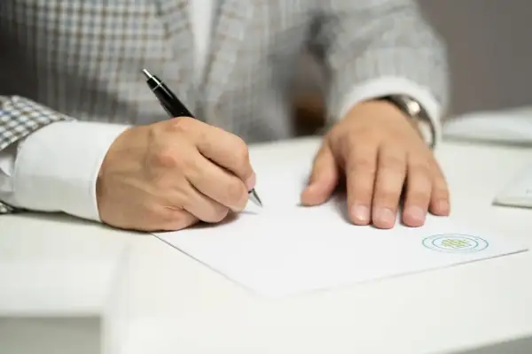 Mężczyzna w garniturze wypełnia dokument, być może wniosek kw-wpis wzór wypełnienia spadek.